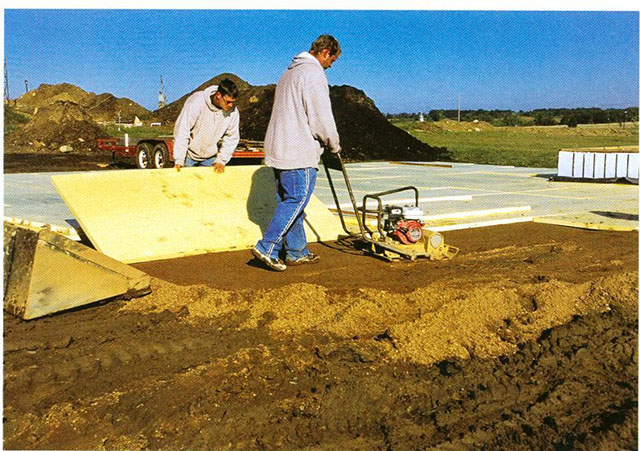 来自Bill Eich Construction的员工安装用于车库板的拆卸泡沫保温。
